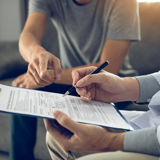 Person filling out paperwork on a clipboard