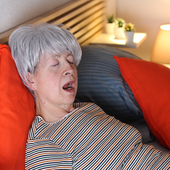 Senior woman sleeping with her mouth wide open