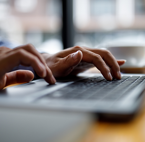 Close up of a person typing on a laptop