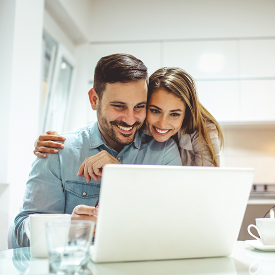 Smiling man and woman looking at a laptop together