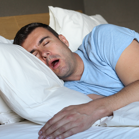Man sleeping on his side with his mouth wide open
