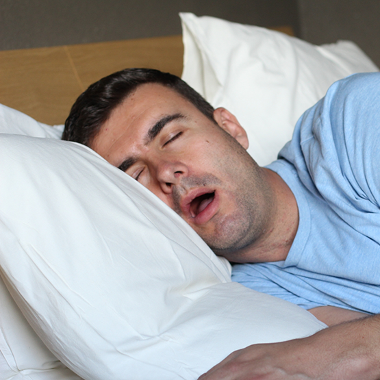 Man sleeping on his side with his mouth wide open
